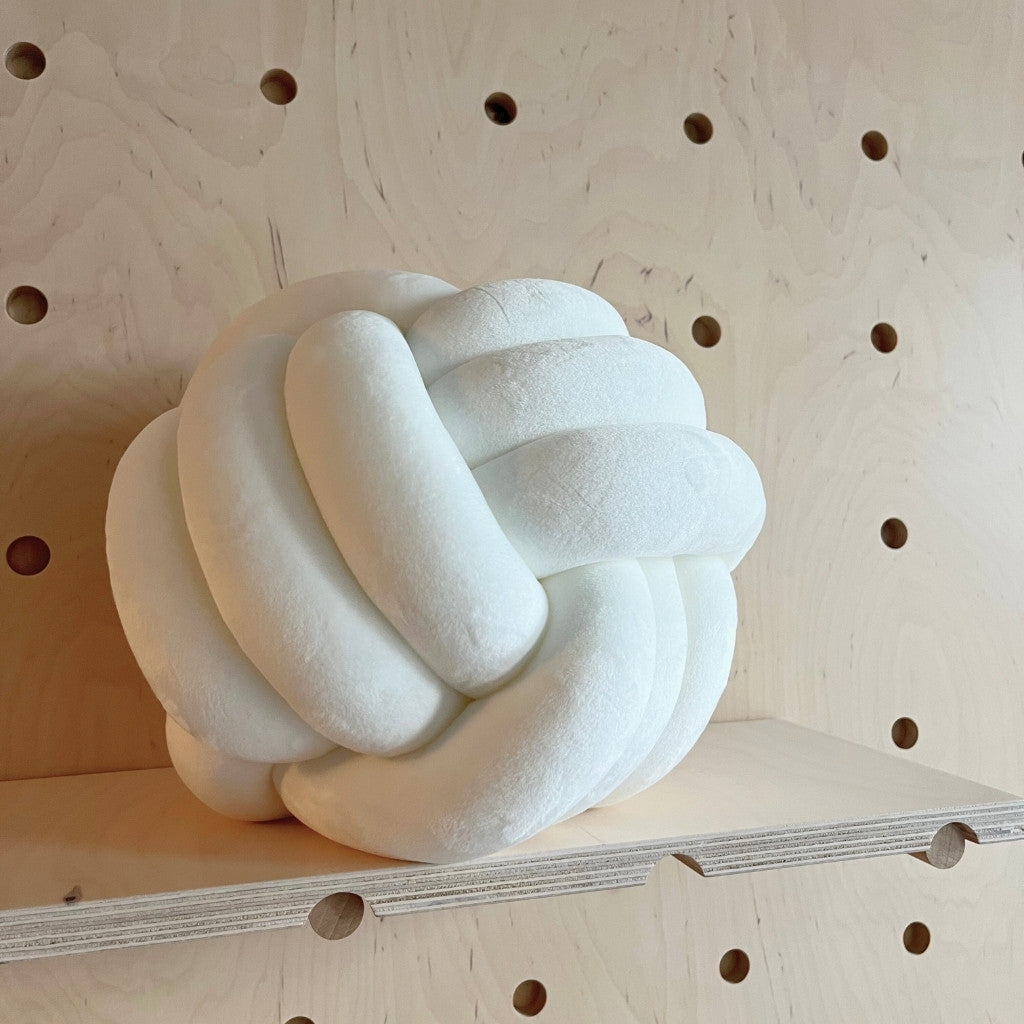 Designový uzlový polštář z jemného plyše v ložnici